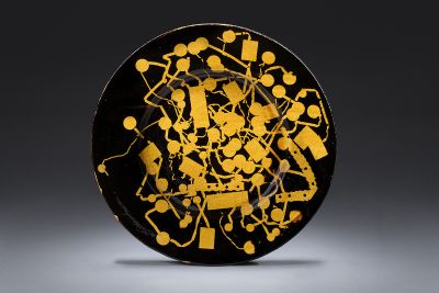 Yellow and brown ceramic platter against a dark background