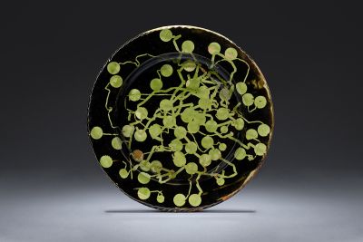 Large brown and green glazed platter against a dark background