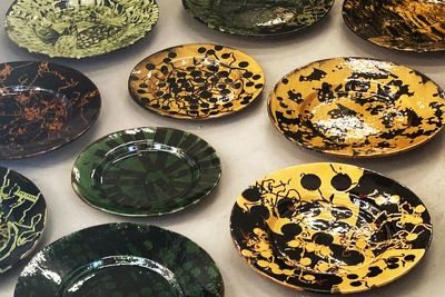 Selection of green, yellow and brown ceramic platters by ceramist Florence Dwyer, decorated with leaf resist patterns